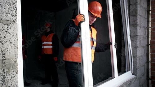 Man insert a plastic window in the opening in the building