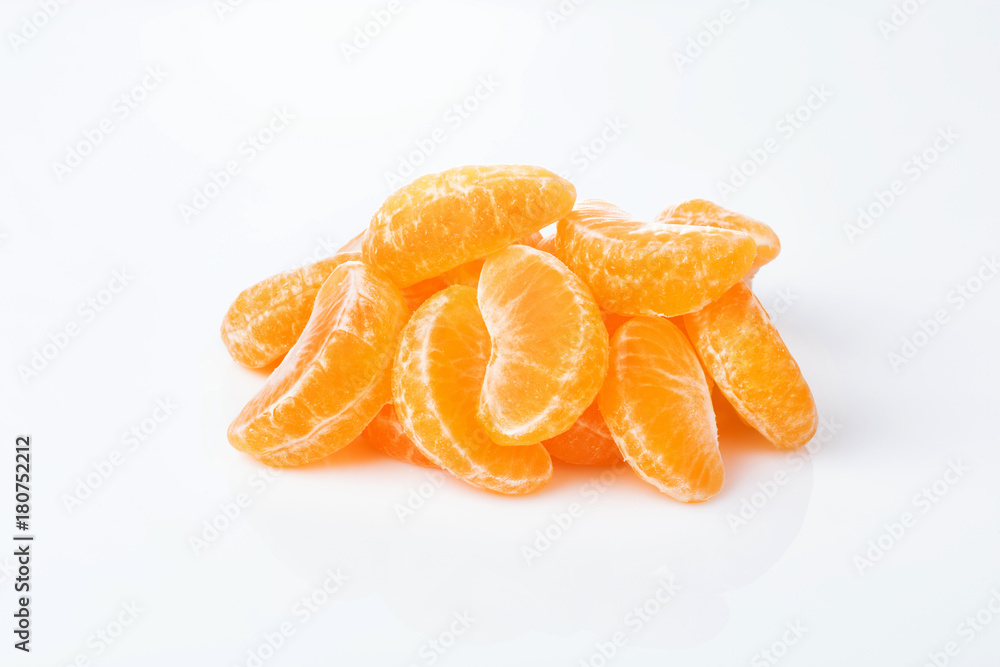 peeled slices of mandarin lie hill isolated on white background. peeled slices of mandarin lie hill isolated on white background.