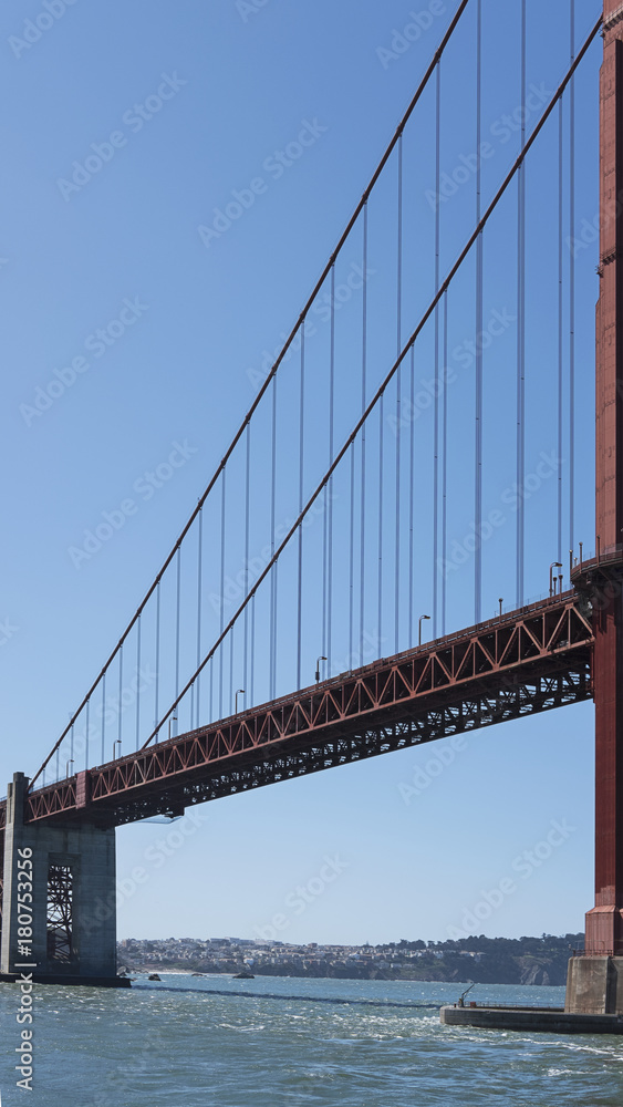 Vertical section of the suspension and cropped view of south tower of the iconic Golden Gate Bridge, San Francisco, California, USA