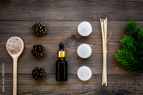 Skin care and relax. Cosmetics and aromatherapy concept. Pine spa salt and oil on dark wooden background top view