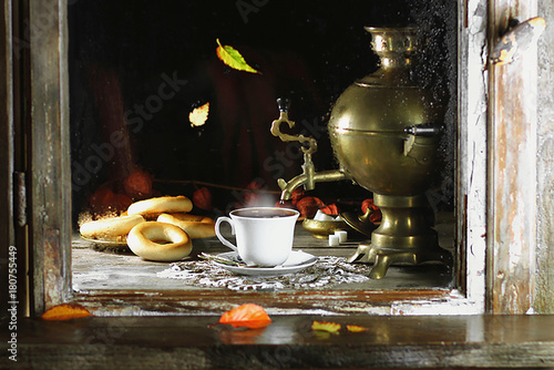 горячий чай с самоваром и осенними листьями на подоконнике