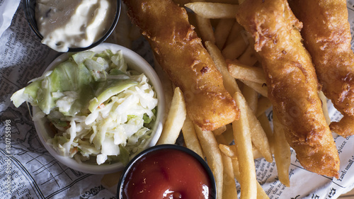Photography View from above of tasty plate of fish and chips, coleslaw and salsas served in