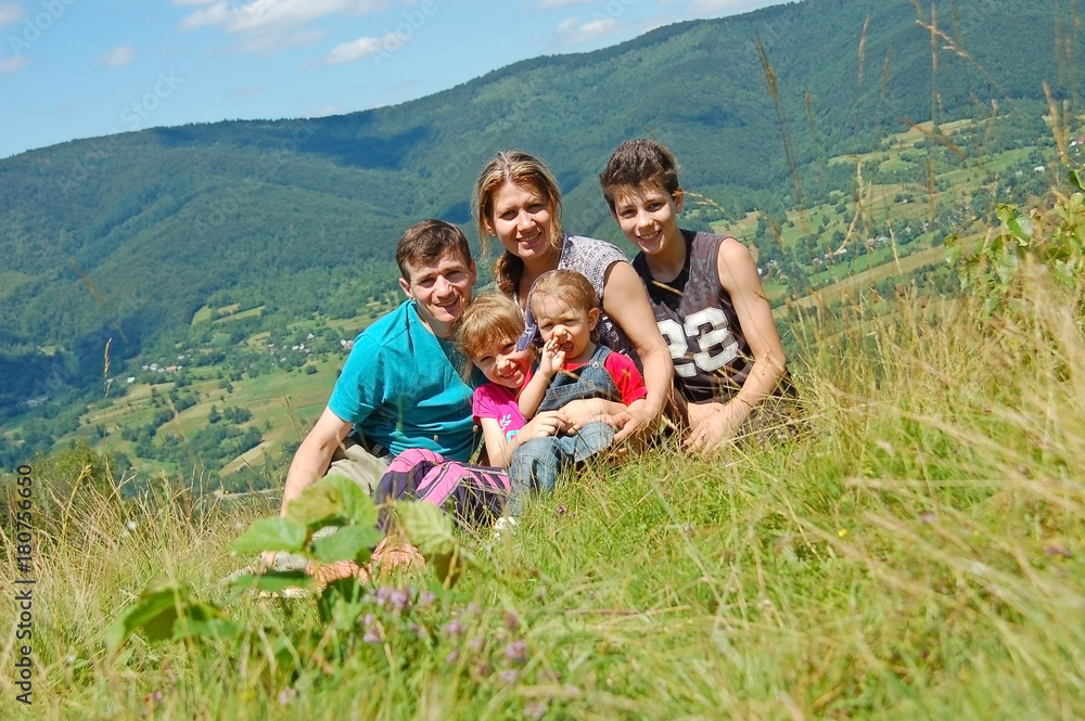 Happy family is resting in the mountains. They sat down to rest, drink water after a hard climb to the mountain Happy family is resting in the mountains. They sat down to rest, drink water after a hard climb to the mountain