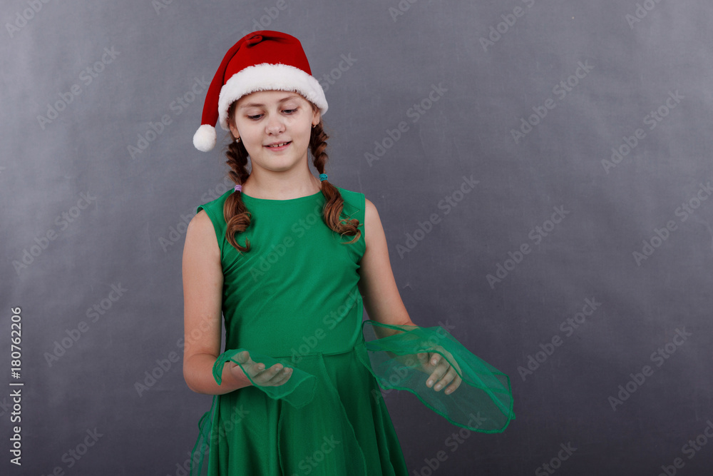 Portrait of little girl in santa hat on grey background Portrait of little girl in santa hat on grey background