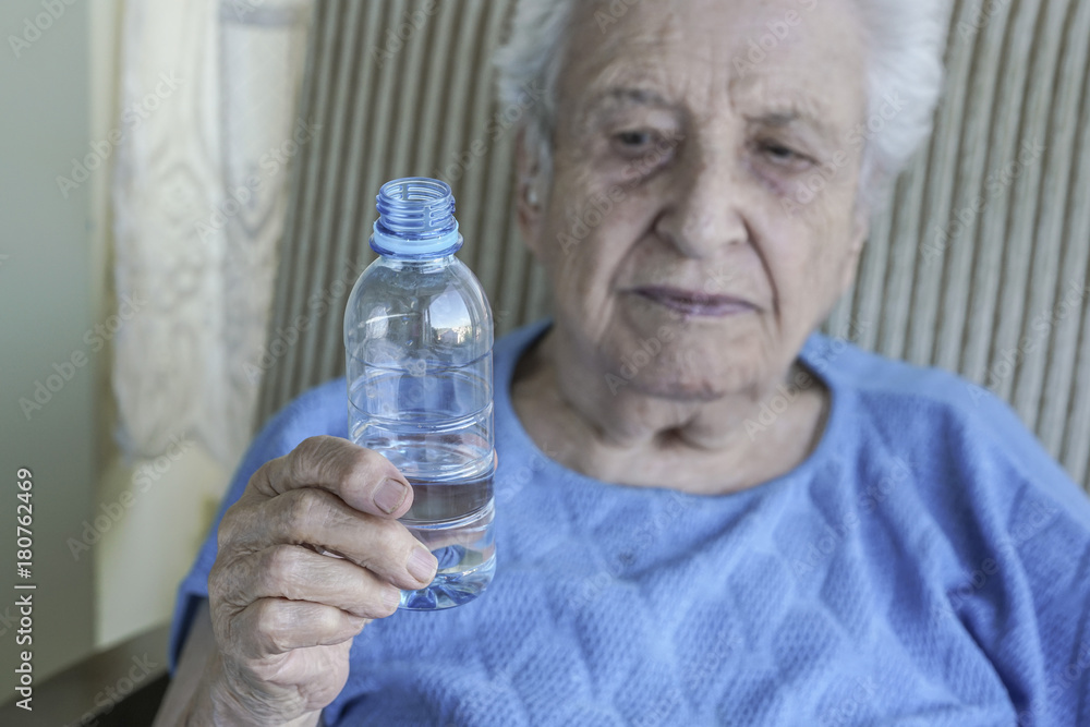 senior woman holding a bottle of drinking water senior woman holding a bottle of drinking water