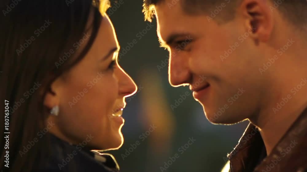 Portrait of a happy couple in the spotlight on a dark background. Declaration of Love
