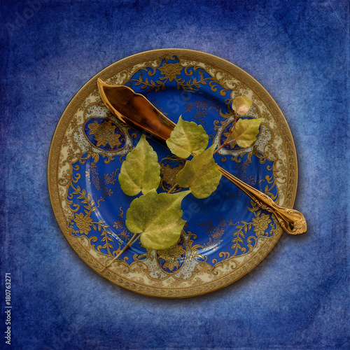 Place setting, plate with leaves and fish knife photo