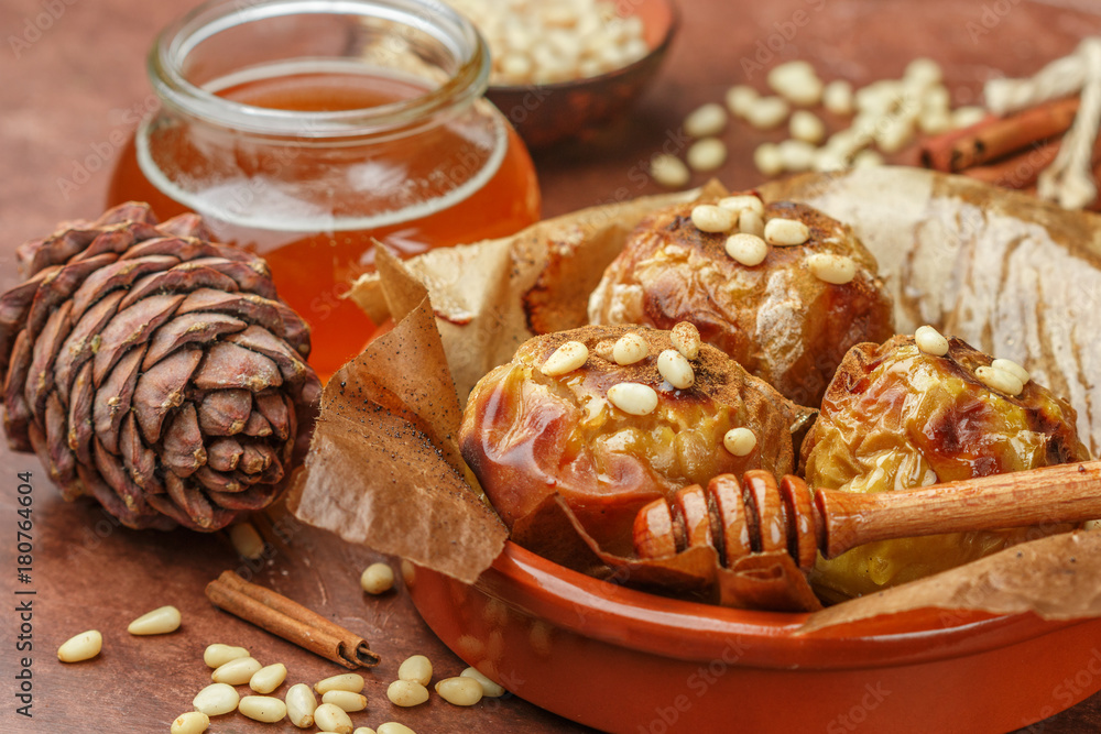 Baked apples with pine nuts, honey and cinnamon. Traditional fall and winter dessert. Selective focus Baked apples with pine nuts, honey and cinnamon. Traditional fall and winter dessert. Selective focus