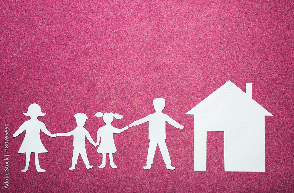 Paper figures of family holding hands near house. Happy family and home concept. Parents and children's on pink background Paper figures of family holding hands near house. Happy family and home concept. Parents and children's on pink background
