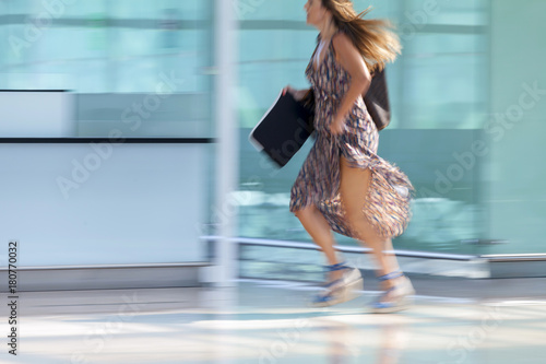 Woman running at the rush hour at the airport with motion blur effect