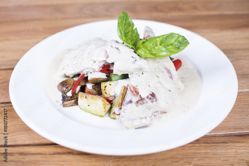 Barbecued chicken with roasted potatoes and vegetables. Delicious meat covered with gravy. Barbecued chicken with roasted potatoes and vegetables. Delicious meat covered with gravy.