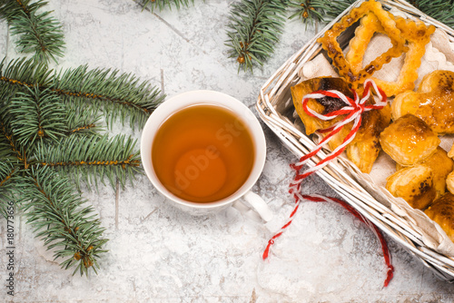 Tea with gingebread cookies in christmas evening. Cup near spruce branch on white wooden background top view copyspace photo