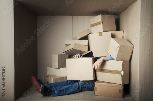 teenager student in small office littered with boxes, concept - too much work