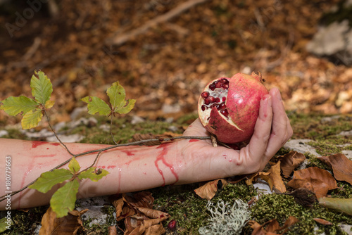 Closeup of Pomegranate in woman's hand. Autumn, Mediterranean forest. Rite, lymph, nourishment, life.