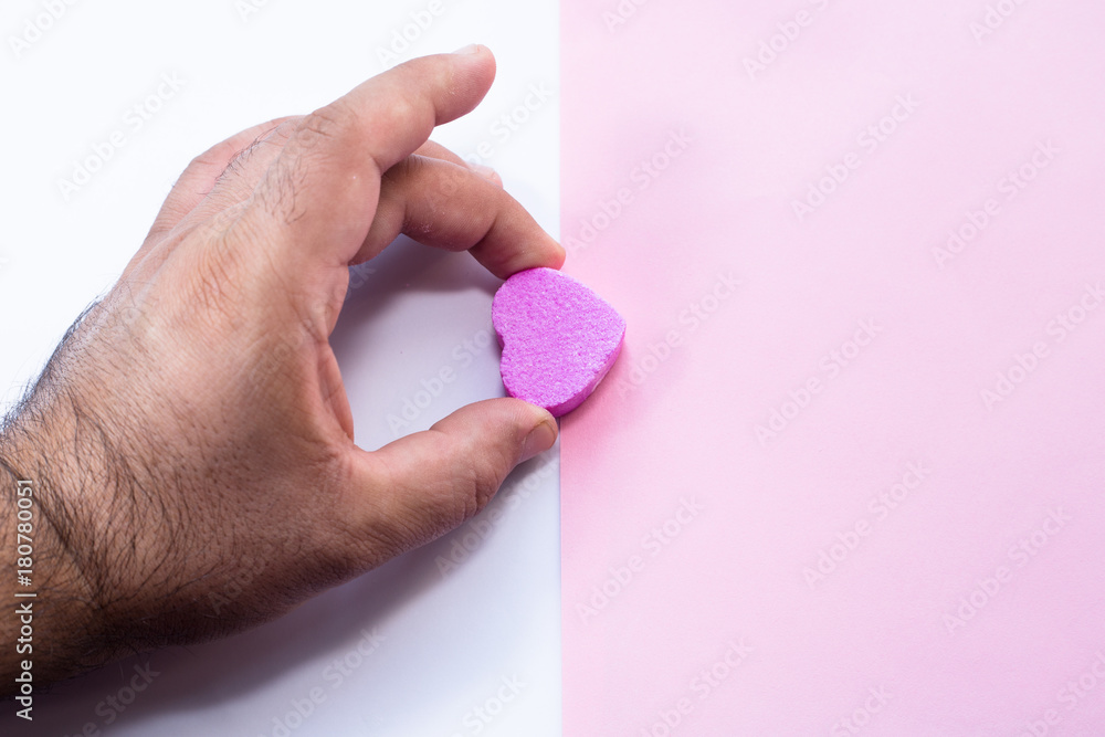 Hand holding heart-shaped candy Hand holding heart-shaped candy