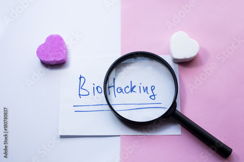 biohacking - the word written on paper wuith two heart-shaped sugar candies. photo
