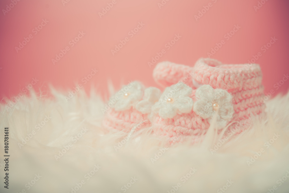 Close up Baby girl knitted shoes on white blanket background.Happy new year greeting card with copy-space. New born celebration holiday concept. Close up Baby girl knitted shoes on white blanket background.Happy new year greeting card with copy-space. New born celebration holiday concept.