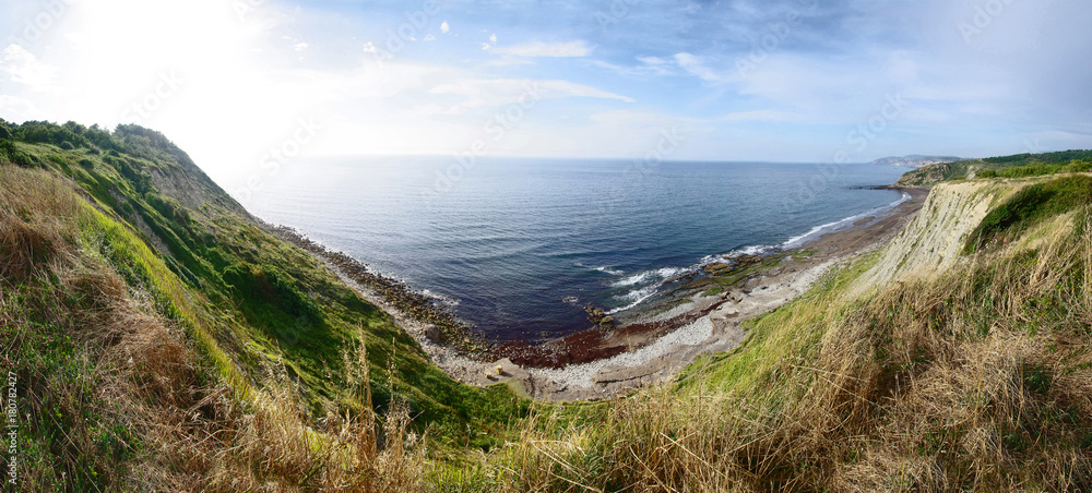 Beautiful view of seashore. Rocks, beach and sea against blue sky. Beautiful view of seashore. Rocks, beach and sea against blue sky.