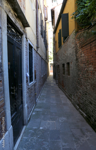 Fototapeta Naklejka Na Ścianę i Meble -  narrow Venetian street called Calle in Italy