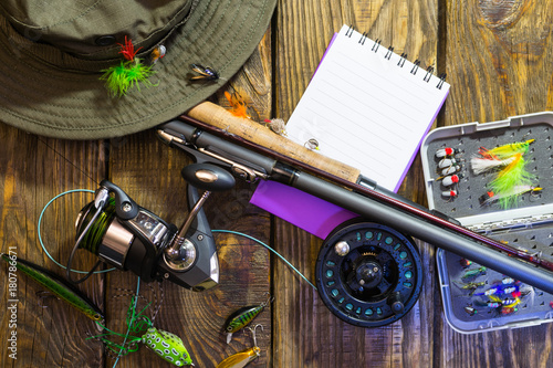 Spinning, fly fishing, flies, spinners, hat and frame for your label lying on a wooden table.