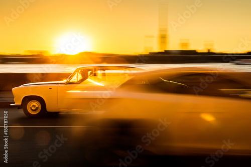 Moving cars on sunset   Two moving cars on background of setting sun in Saint Petersburg  Russia. 