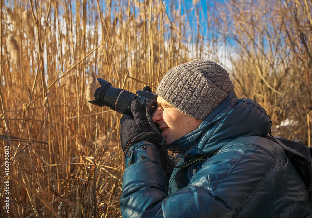 Closeup of photographer with digital camera outdoors. Young man photographs nature. Closeup of photographer with digital camera outdoors. Young man photographs nature.