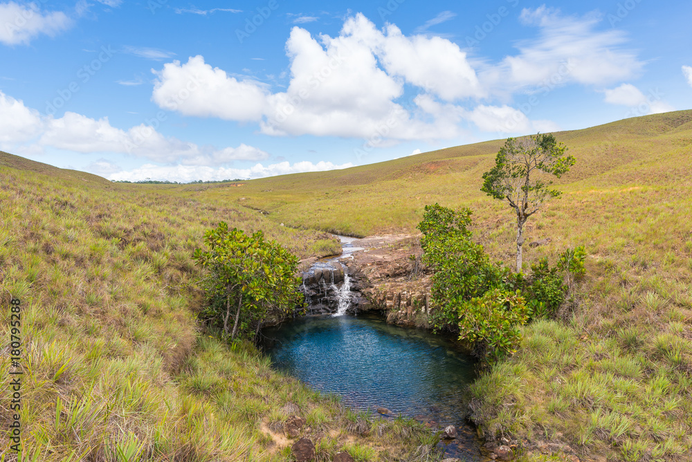 Natural blue pond with small waterfall in Gran Sabana region, in south-eastern Venezuela