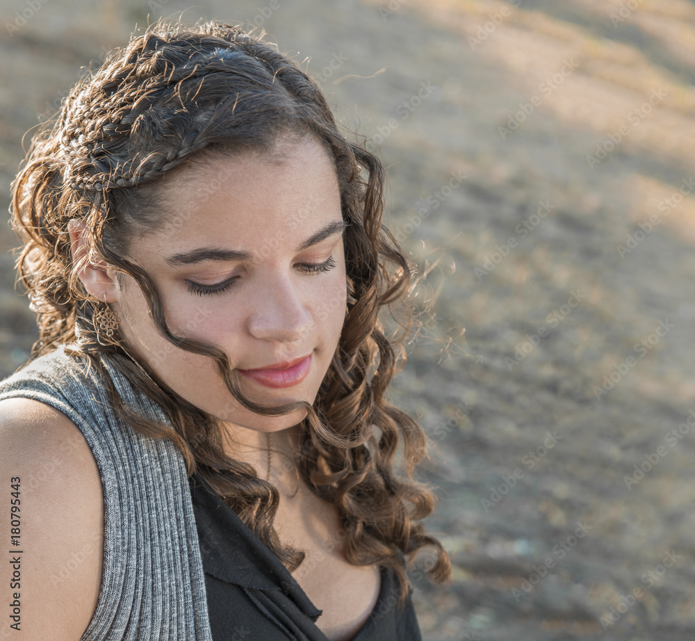 Outdoor portrait of beautiful young woman with curly, braided hair Outdoor portrait of beautiful young woman with curly, braided hair