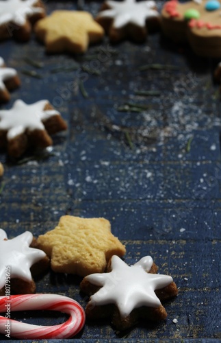 Xmas background with Christmas star cookies and gingerbread men on blue wooden frame, copy space