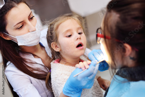 baby girl helping a dentist examine a patient