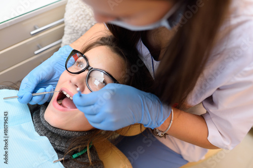 cute young woman with glasses in dental chair