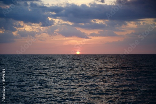 Circular Sun Sets over Wave Ocean