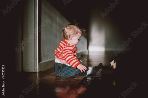 baby playing with a box in the hall photo