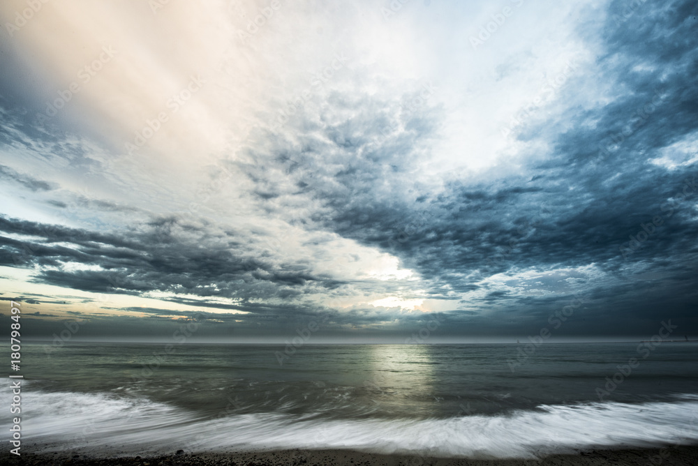 Obraz premium Ocean view from beach with dramatic clouds overhead
