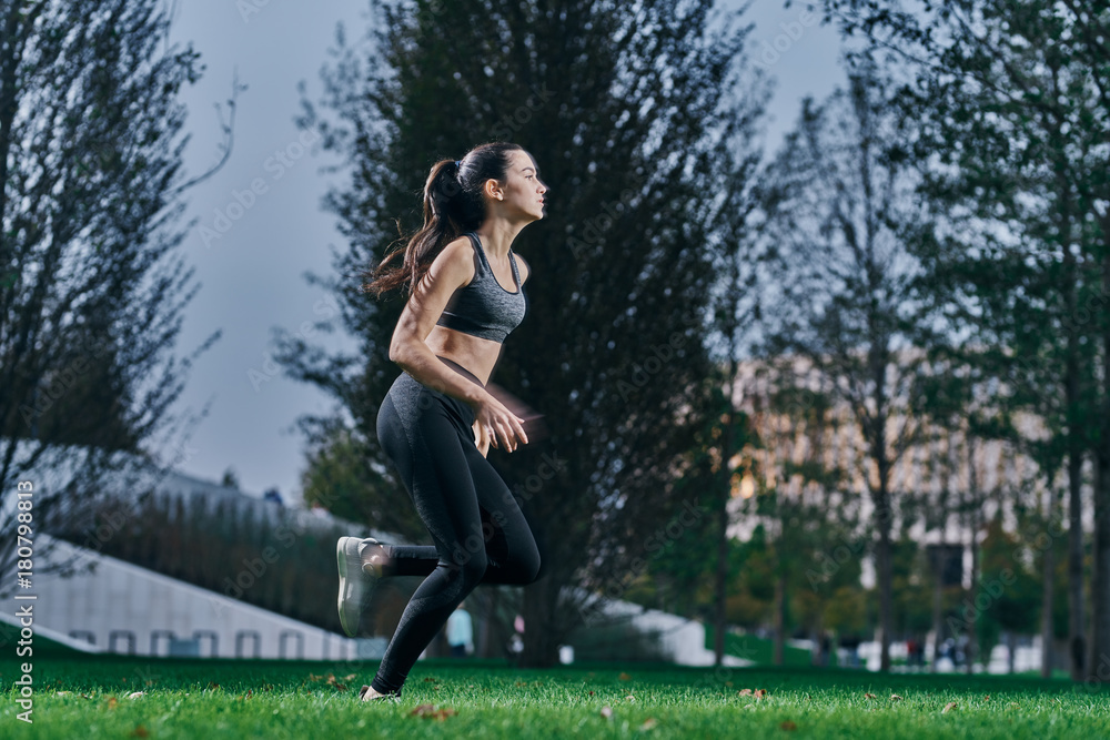 sporty girl in motion against a tree background