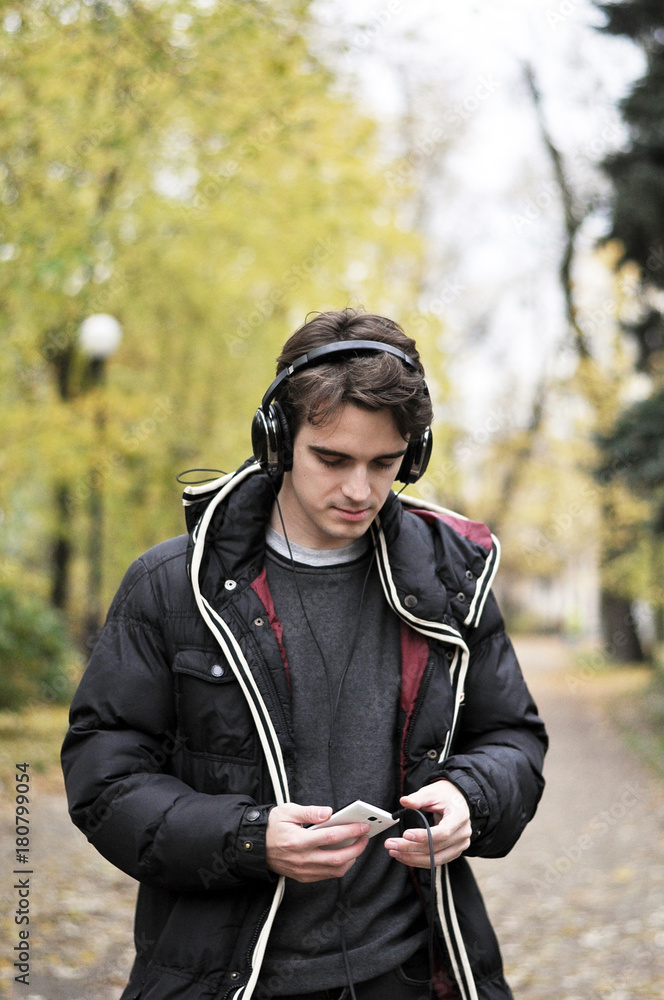 Obraz premium A boy focused on searching for the music in the park