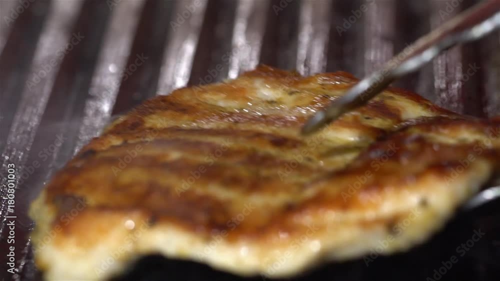 A piece of meat is fried on a grill, close-up A piece of meat is fried on a grill, close-up