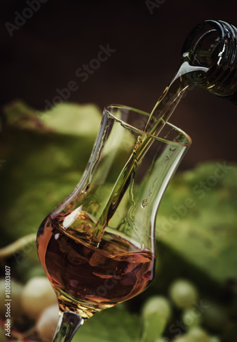 Golden Alcoholic Drink Being Poured Into Shot Glass, Rustic Still Life, Selective Focus