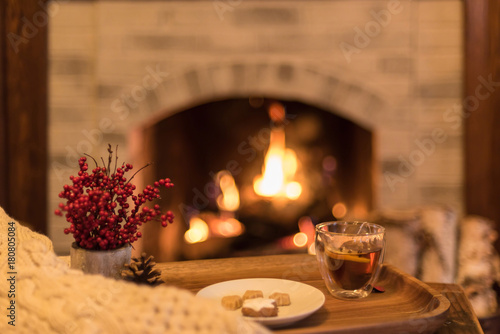 Hot tea with lemon and clove in front of a cozy fire