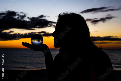 Woman Silhouette in a Colorful Sunset with Glass Ball
