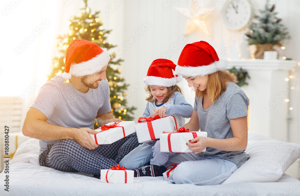Fototapeta premium happy familymother father and child on Christmas morning in bed