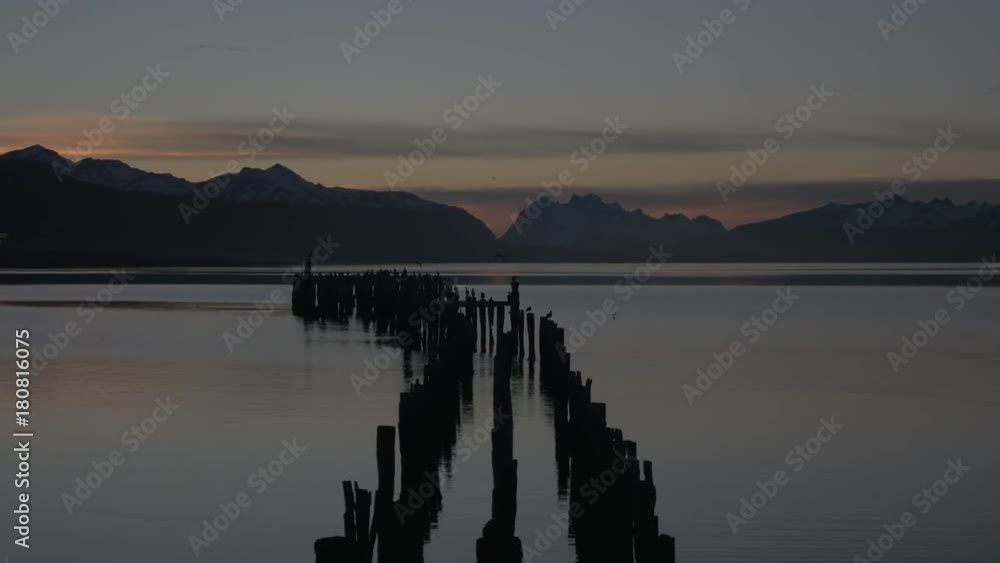 Wide, mountains tower over lake at sunset