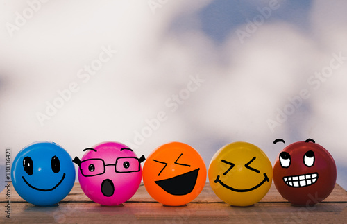 Happy Cheerful Smiley face yellow, orange, red, blue and pink balls with bokeh wall background and copy space photo