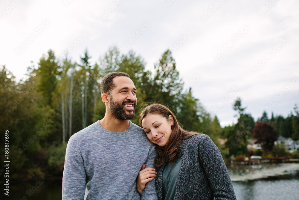 Fototapeta premium Black and white couple cuddling at the lake