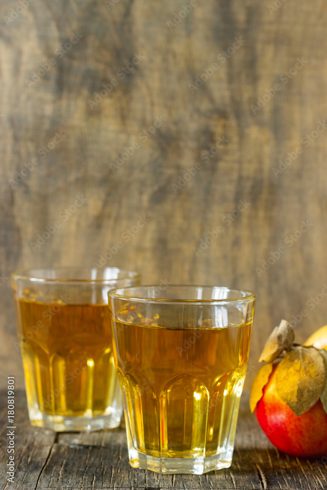 Apple juice in glasses and fresh apples on a wooden background. Rustic style. Apple juice in glasses and fresh apples on a wooden background. Rustic style.