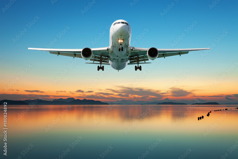 Airplane flying over tropical sea at beautiful sunset or sunrise scenery background. Airplane flying over tropical sea at beautiful sunset or sunrise scenery background.