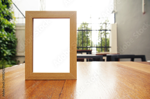 Mock up Menu frame standing on wood table in Bar restaurant cafe. space for text.