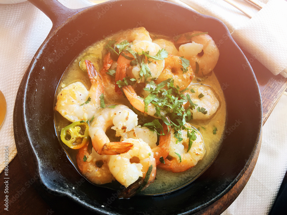 Shrimp in a garlic sauce with parsley in a frying pan