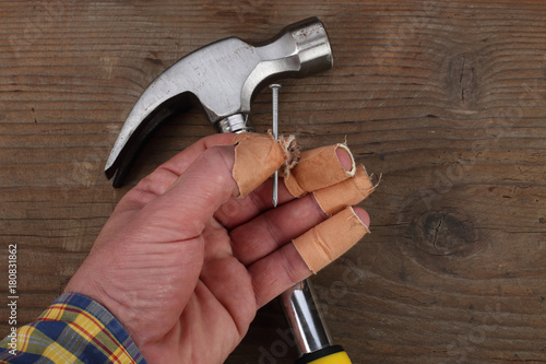 Carpenter hand fingers and hammer photo