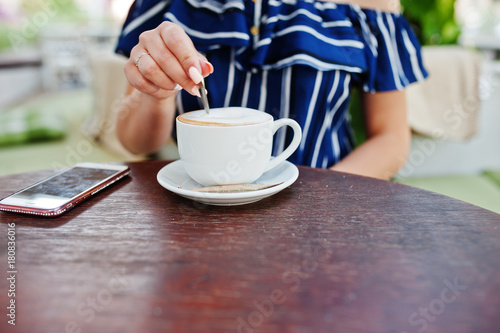 Close up hands with sugar and cup of coffee.